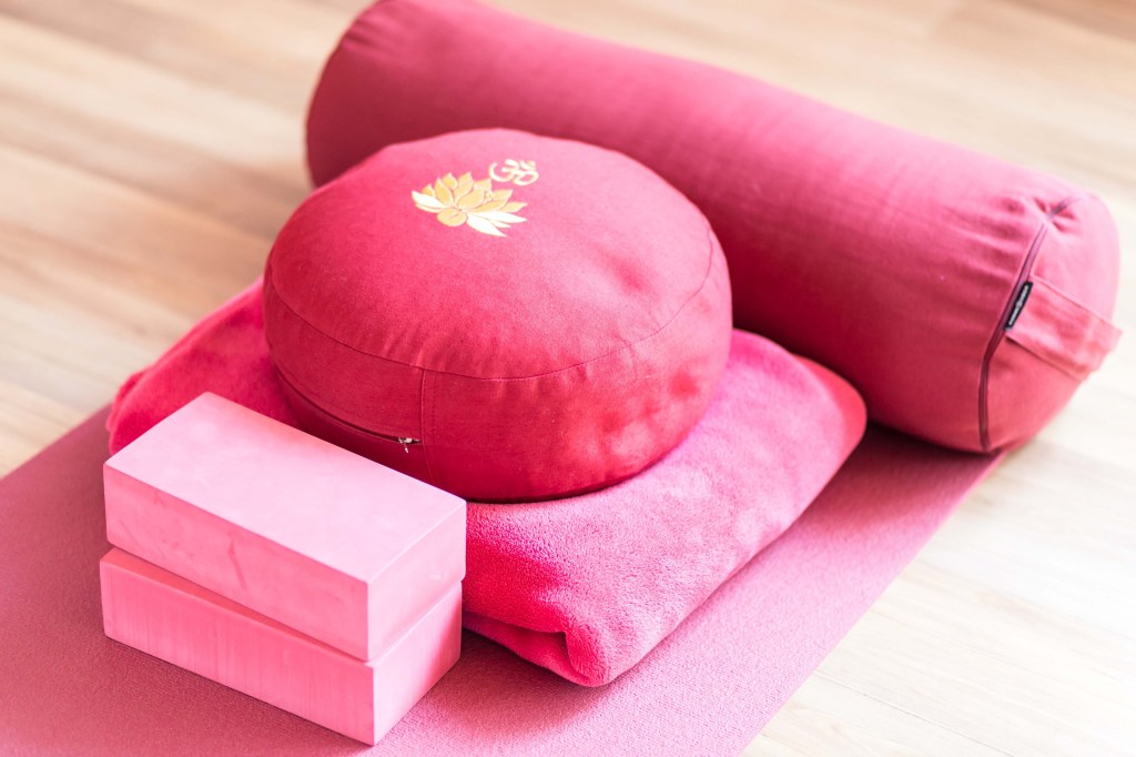 Pink yoga equipement: blocks, meditation pillow, blanket, bolster and mat. Photo credit: anja828 / Pixabay